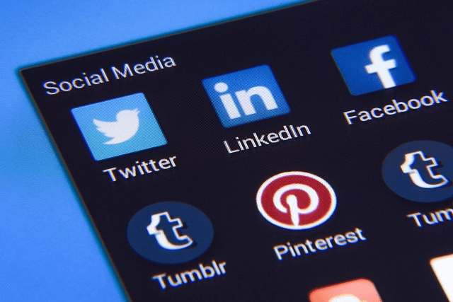 A close-up of a mobile phone with social media (Facebook and Twitter) icons