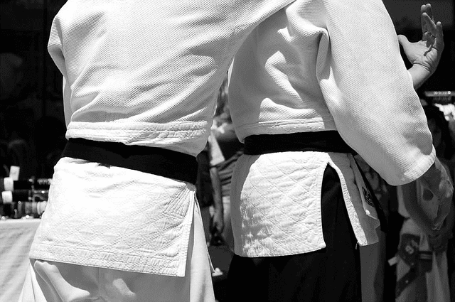 A close-up of the black belts of two martial artist